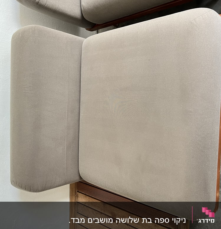 כריות ספה אפורות מונחות על משטח עץ